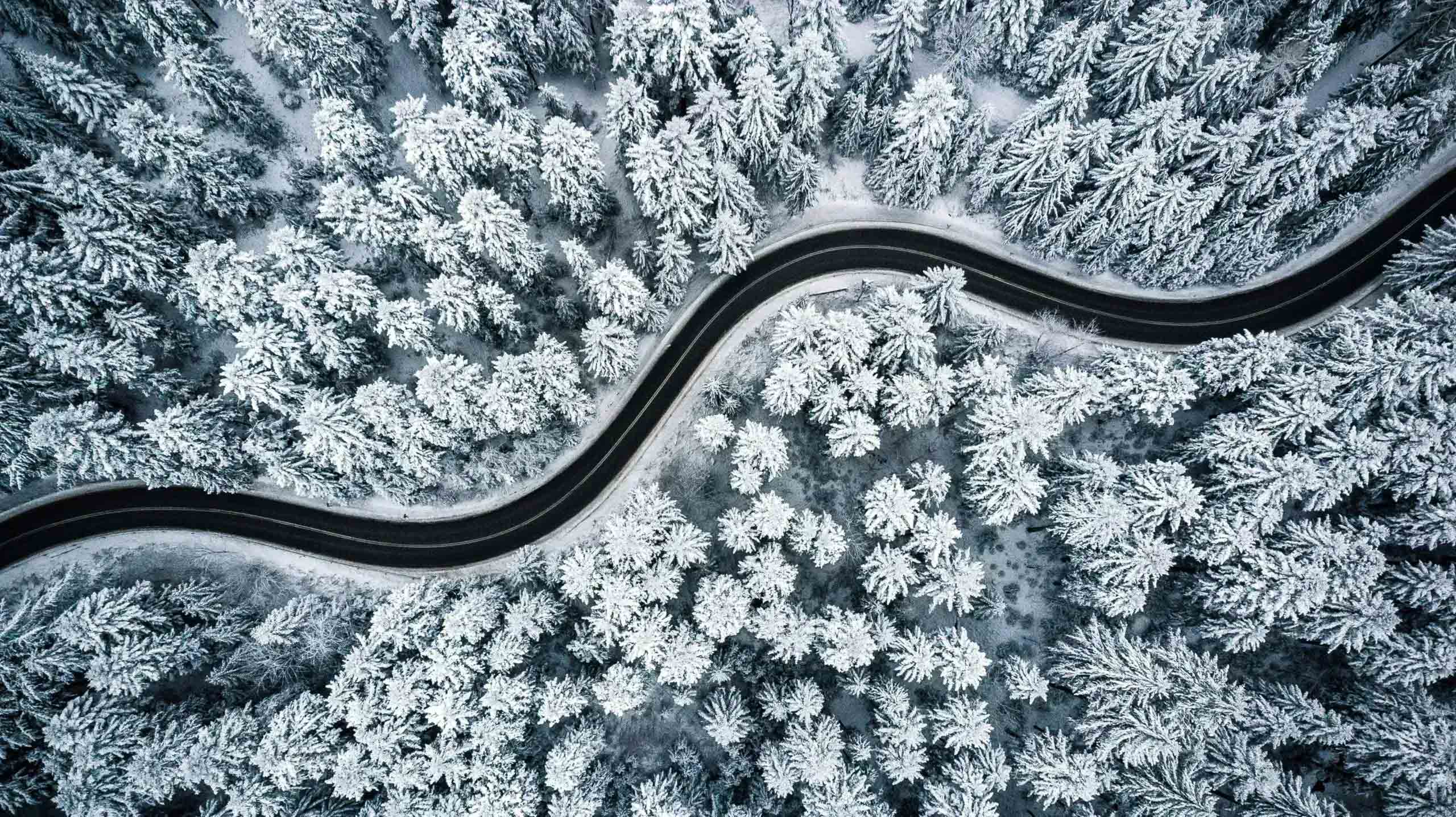 Droonikuva lumisesta metsästä ja mutkittelevasta tiestä. Epäselvät roolit ja vastuut hidastavat työtä. Proinno auttaa selkeyttämään vastuita.